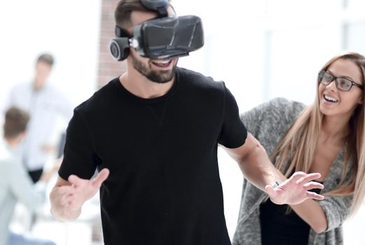 Attractive bearded man enjoyingvirtual reality glasses in modern interior design studio.Home play concept.