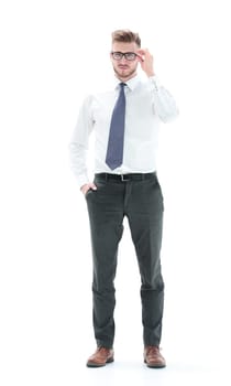 in full growth.young businessman adjusting his glasses.isolated on white background