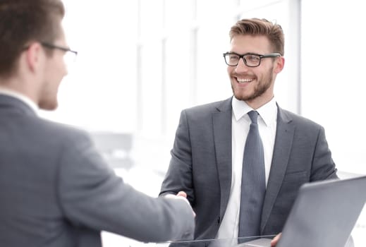 close up.smiling business people shaking hands in office.business concept