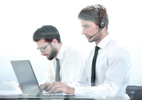 Manager with the headset uses a laptop to work with the client .photo with copy space