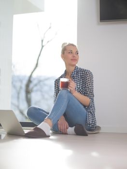 Real Woman Using laptop At Home on the floor Drinking Coffee Enjoying Relaxing