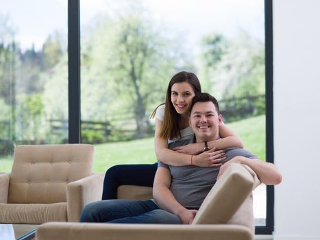 young handsome couple enjoys hugging on the sofa in their luxury home villa