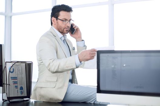 concerned businessman talking on his smartphone sitting on his Desk.business concept