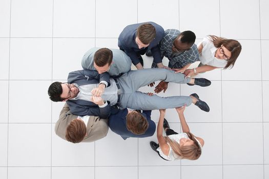 top view.a fun business team is rocking their leader .winning concept