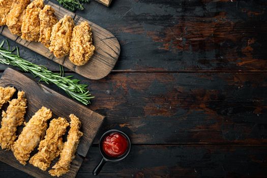 Southern fried chicken cuts on dark wooden background, flat lay, with space for text.