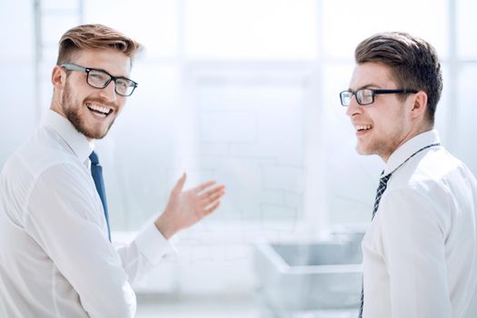 rear view.happy business colleagues standing in a bright office .photo with copy space