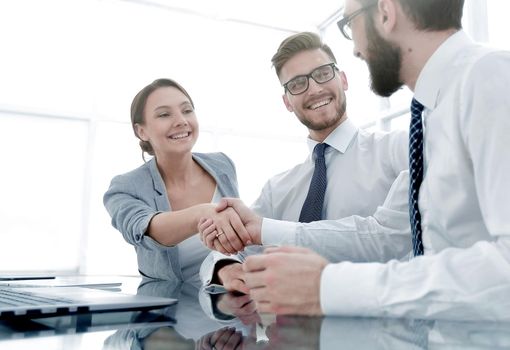 background image.handshakes colleagues at the Desk .business concept