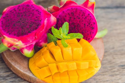 Sliced dragon fruit and mango on an old wooden background.