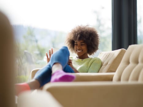 Young african american woman at home relaxing in her luxury lliving room reading a digital tablet  surf internet and work