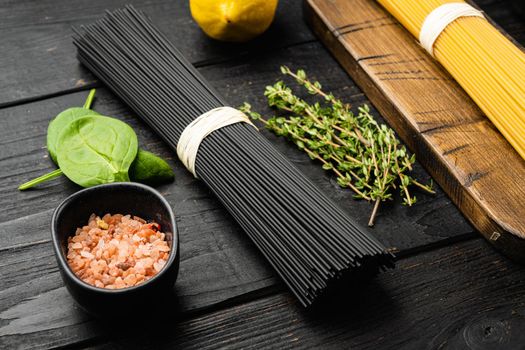 Three colors dry raw pasta set, on black wooden table background