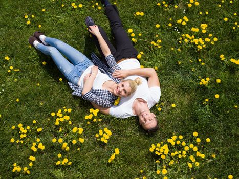 Overhead view of young man and woman lying on the grass, Top view of relaxed young couple lying down on meadow.