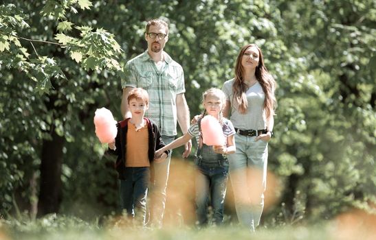 portrait of a young family on the background of the Park.the concept of family entertainment