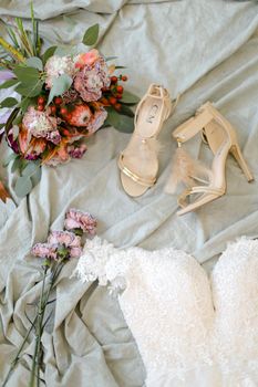 Bridal shoes and flowers. Concept of fiancee wear and wedding photo session.