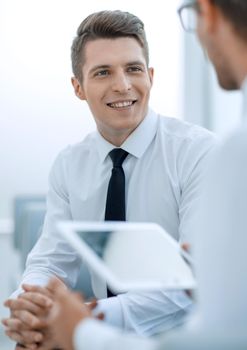 close up.businessman with a digital tablet talking to his colleague.photo with copy space