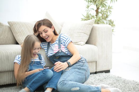 mother and her little daughter use a smartphone to view the photo.photo with copy space