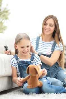 background image.Mother with a little daughter sitting on the couch at home