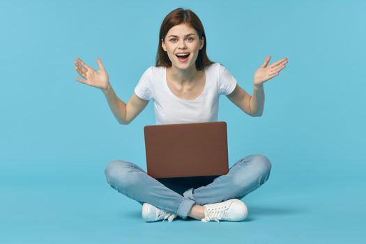 woman with laptop learning internet online education blue background. High quality photo