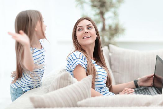 mom and daughter sitting on the couch in the living room.happy together