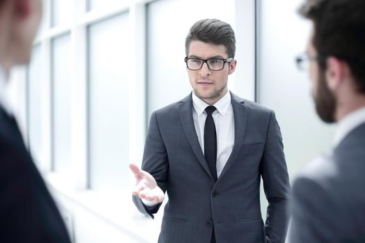 boss talking to employees standing in the office.business concept