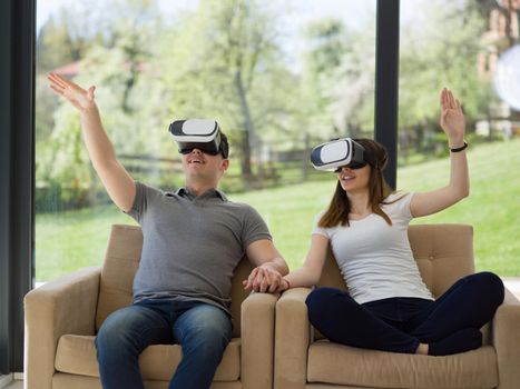 Couple using virtual reality headset in living room at home  people playing game with new trends technology