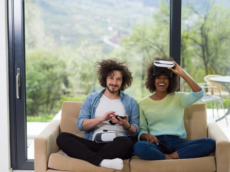 Multiethnic Couple using virtual reality headset in living room at home  people playing game with new trends technology