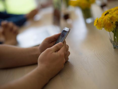 Young man holding on his smartphone in the office close up