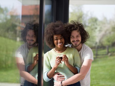 romantic happy young multiethnic couple enjoying morning coffee by the window in their luxury home