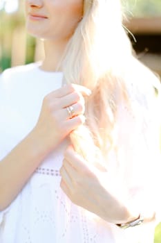 Blonde woman with gold rings on right hand. Concept of married female person.