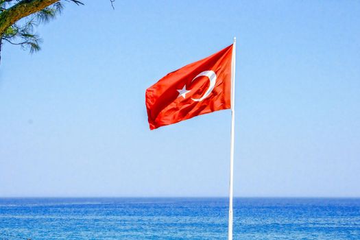 Turkey flag on the background of the sea and blue sky. In the summer while relaxing at sea.