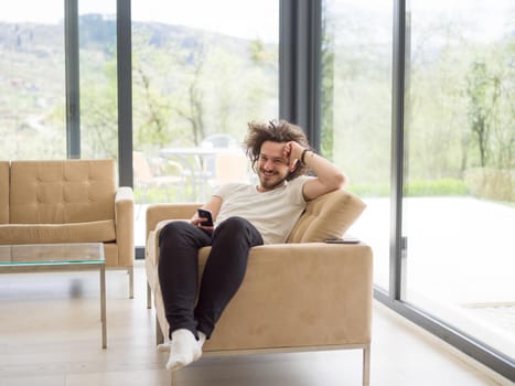 Handsome casual young man using a mobile phone at luxurious home