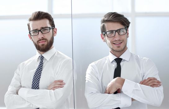 Two happy confident young businessmen standing with arms crossed in office.business concept