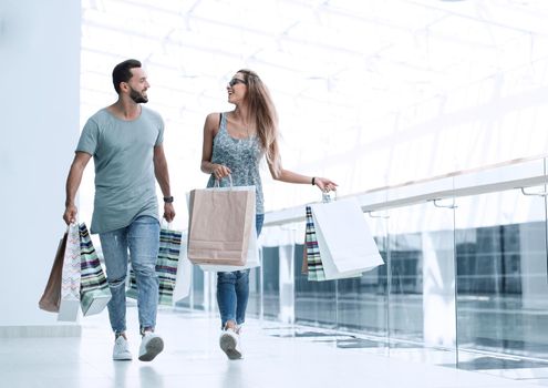 young couple with shopping bags discussing something.photo with copy space