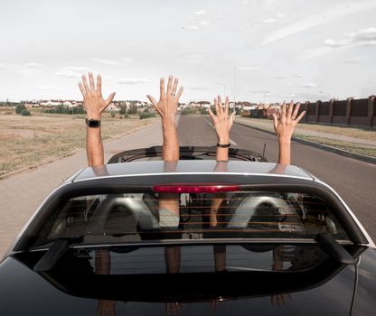 group of happy young people waving from a convertible car.photo with copy space