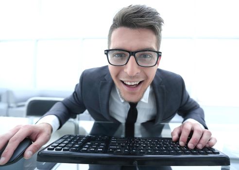 businessman working in office, sitting at desk, typing on keyboard