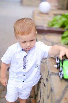 Little male child playing with toy car. Concept of childhood and toys.