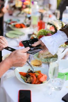 Hands keeping black cards in table background. Concept of playing poker at party.