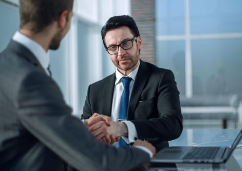 business people shaking hands over a Desk. the concept of unanimity