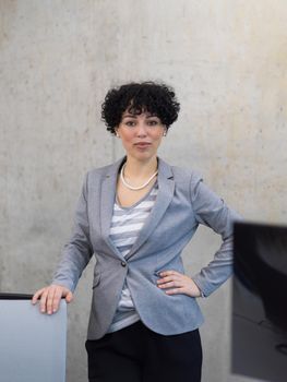 Portrait of successful female software developer with a curly hairstyle at modern startup office