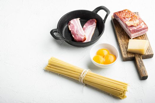 Ingredients for cooking Carbonara pasta, spaghetti with pancetta, egg and hard parmesan cheese set, on white stone surface