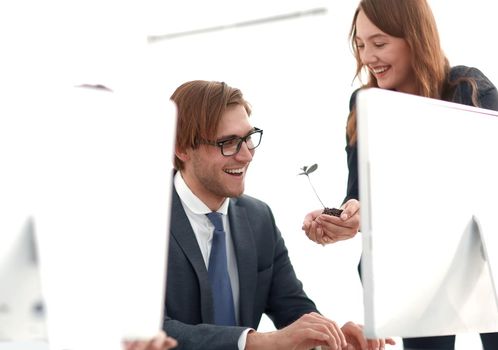 business woman shows the team a green sprout. the concept of a startup