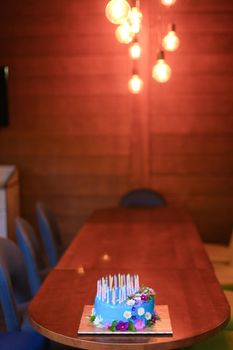 Blue candndles on wooden table. Concept of sweet food for birthday party.