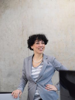 Portrait of successful female software developer with a curly hairstyle at modern startup office