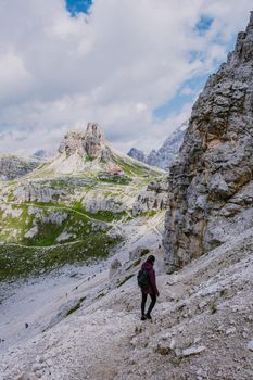 Tre Cime di Lavaredo peaks or Drei Zinnen at sunset, Dobbiaco Toblach, Trentino -Alto Adige or South Tyrol, Italy. Europe Alps. Asian woman hiking in the mountains