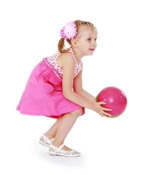 Little girl in a pink dress catches the ball. Isolated on white background .
