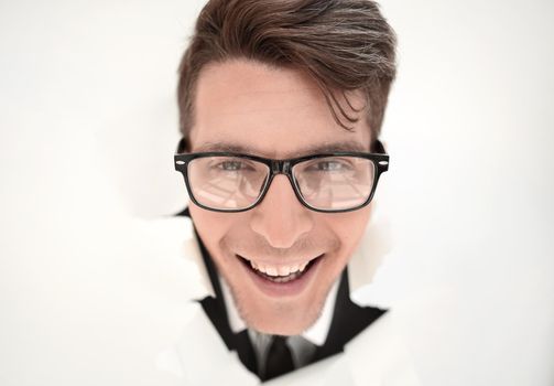 young businessman breaking through a white paper wall.photo with copy space