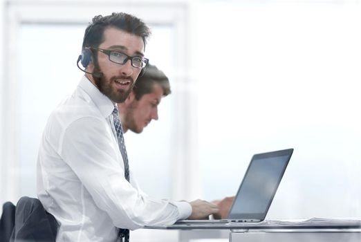 business man in headphones sitting at his Desk.photo with copy space.