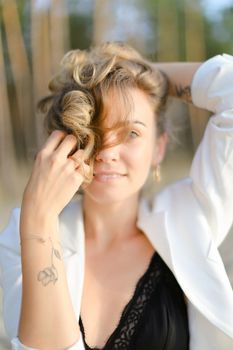 Portraint of young caucasian girl with little hand tattoo wearing white shirt and black bra. Concept of beauty.