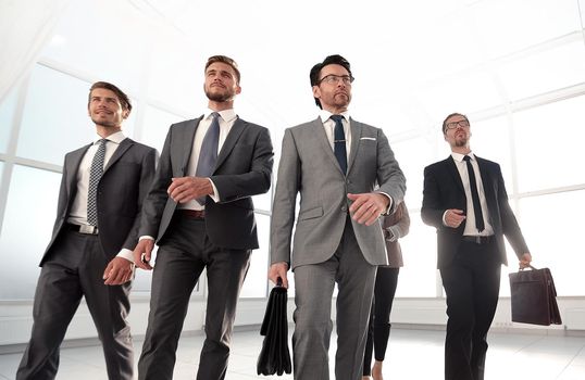 Confident business partners walking down in office building and talking