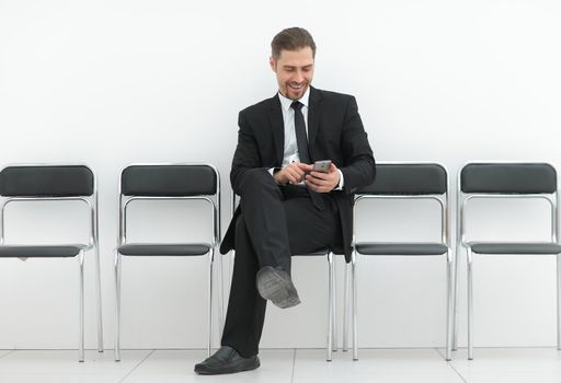 businessman with mobile sitting in the office hallway.photo with copy space