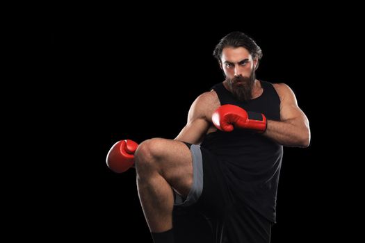 Kickboxer man fighting against black background. Sport concept